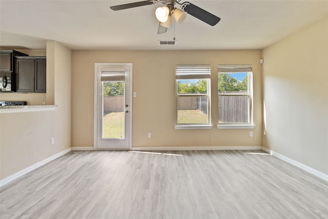 spare room featuring ceiling fan, plenty of natural light, and light hardwood / wood-style flooring