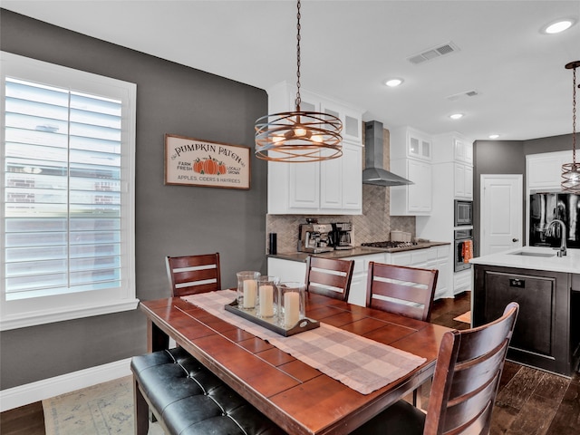 dining room featuring a chandelier, sink, and dark wood-type flooring