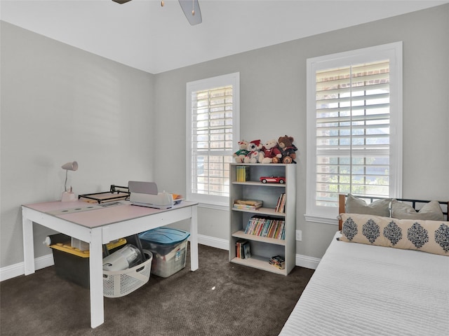 interior space with plenty of natural light, dark carpet, and ceiling fan