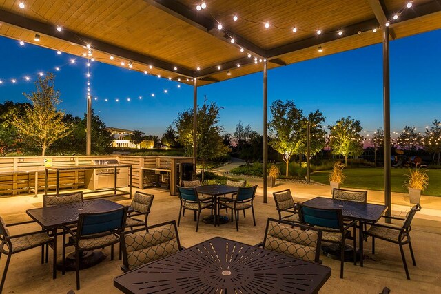 patio terrace at dusk featuring an outdoor kitchen