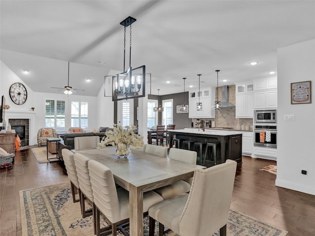 dining area with a healthy amount of sunlight, dark hardwood / wood-style flooring, and a fireplace