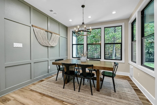 dining room featuring plenty of natural light, hardwood / wood-style floors, and a notable chandelier