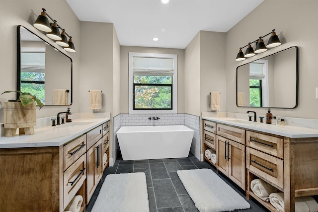 bathroom with a bathing tub, tile patterned flooring, and vanity