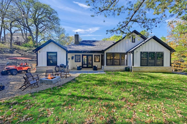 back of property featuring french doors, a patio, a fire pit, and a lawn