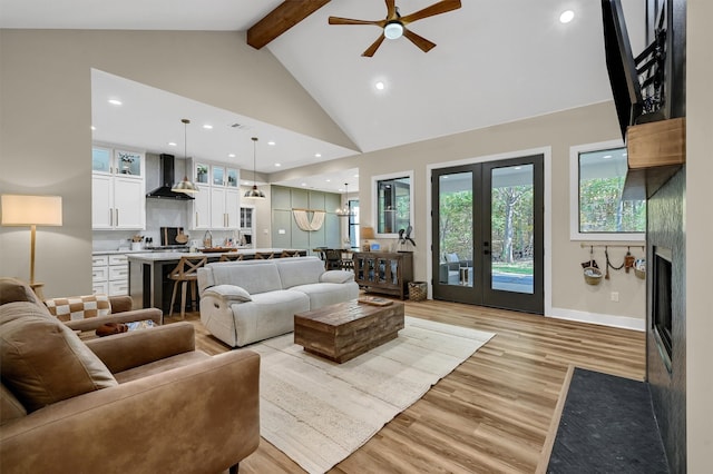 living room featuring french doors, light wood-type flooring, ceiling fan, high vaulted ceiling, and beamed ceiling