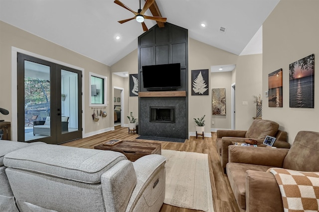 living room featuring hardwood / wood-style flooring, beam ceiling, high vaulted ceiling, and french doors