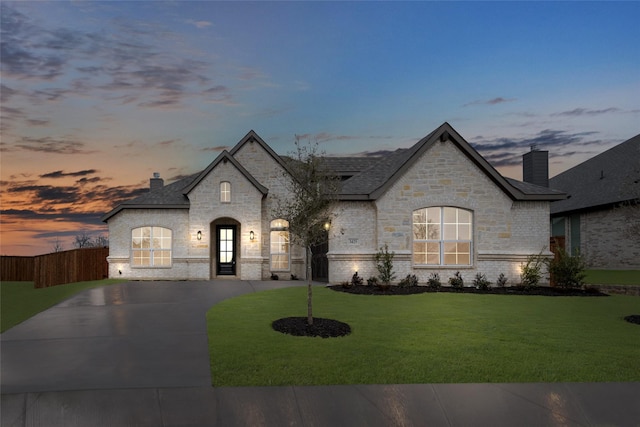 french country home featuring a yard