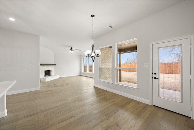 unfurnished dining area featuring plenty of natural light, a fireplace, and wood-type flooring