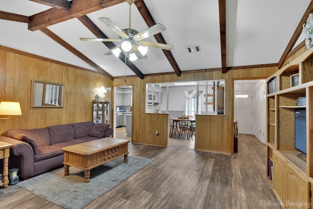 living room featuring beamed ceiling, wood-type flooring, and wooden walls