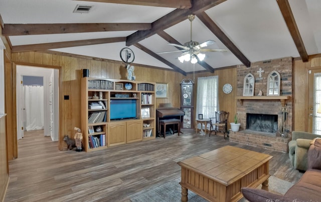 living room featuring hardwood / wood-style floors, lofted ceiling with beams, ceiling fan, and a fireplace