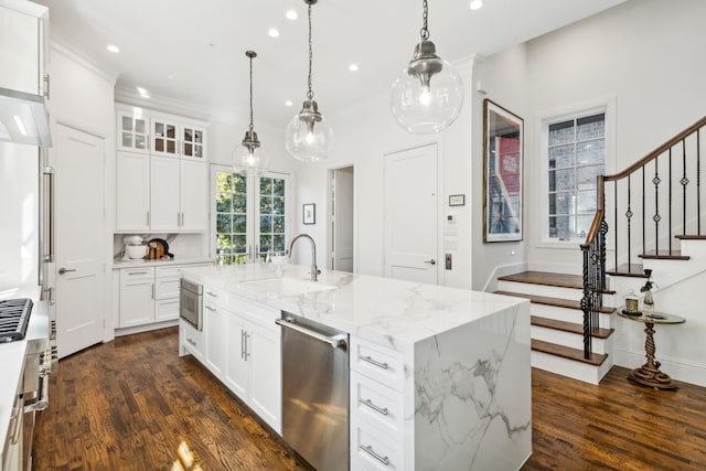 kitchen featuring a kitchen island with sink, sink, white cabinets, and stainless steel dishwasher