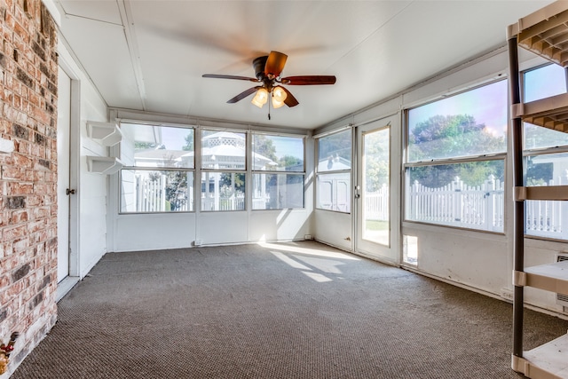 unfurnished sunroom with ceiling fan and plenty of natural light