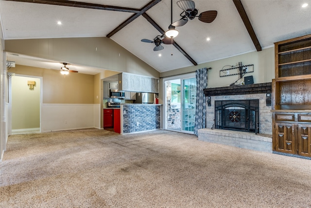 unfurnished living room with carpet flooring, ceiling fan, beam ceiling, high vaulted ceiling, and a fireplace