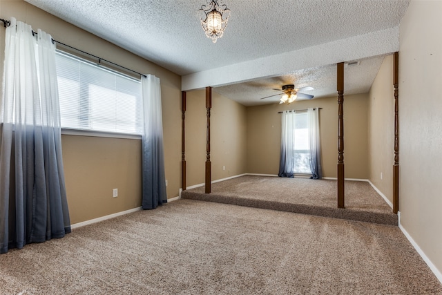 carpeted empty room featuring ceiling fan, a healthy amount of sunlight, and a textured ceiling