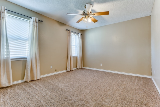 empty room featuring ceiling fan, carpet floors, and a textured ceiling