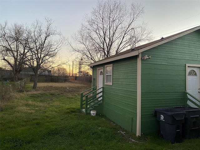 property exterior at dusk with a yard