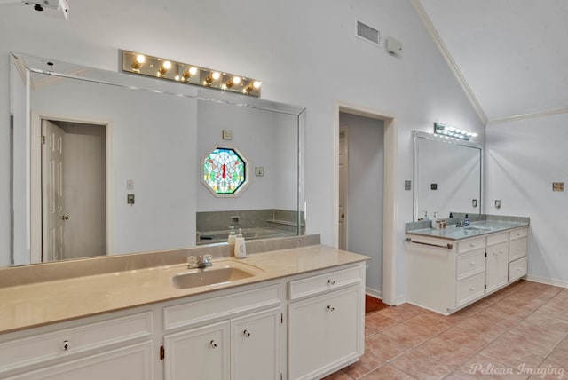 bathroom featuring vanity, a bathtub, tile patterned floors, vaulted ceiling, and ornamental molding