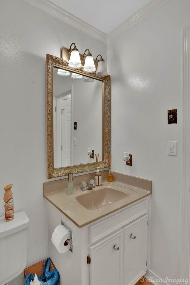 bathroom featuring vanity, toilet, and ornamental molding