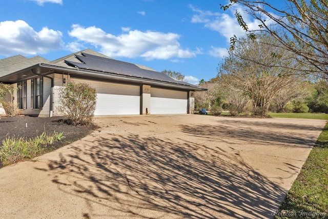 view of home's exterior featuring solar panels and a garage