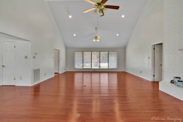 unfurnished living room with hardwood / wood-style floors, ceiling fan, and high vaulted ceiling