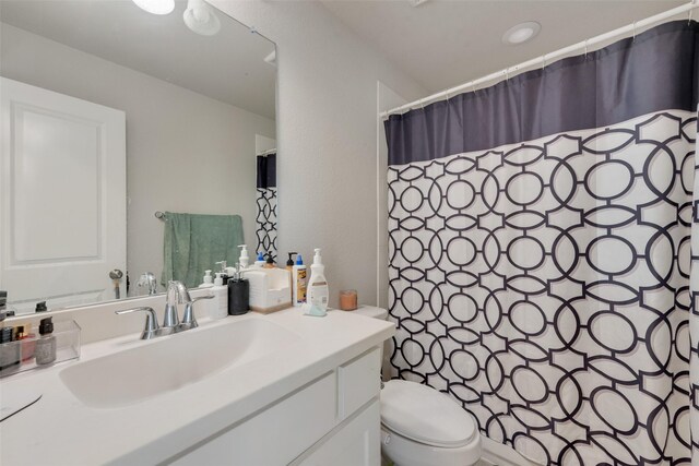 bathroom with vanity, toilet, and curtained shower