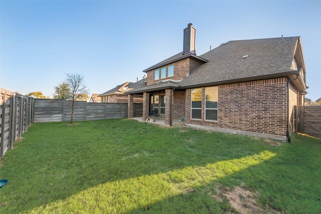 back of property with a yard and a patio area