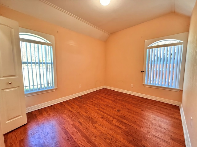 spare room featuring hardwood / wood-style floors and lofted ceiling