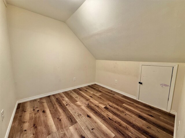 additional living space with wood-type flooring and lofted ceiling