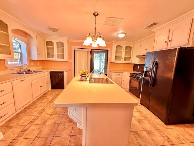 kitchen featuring black appliances, pendant lighting, sink, and a kitchen island with sink