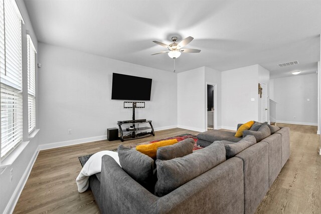 living room featuring light hardwood / wood-style flooring and ceiling fan