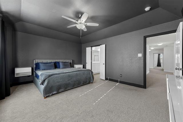 carpeted bedroom featuring ceiling fan, lofted ceiling, and ensuite bath