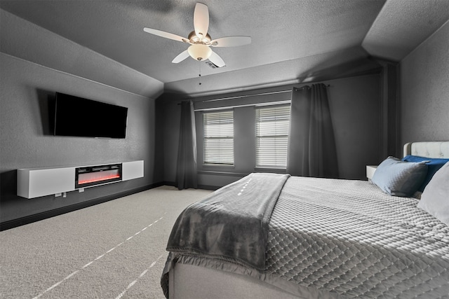 bedroom with a textured ceiling, vaulted ceiling, and ceiling fan