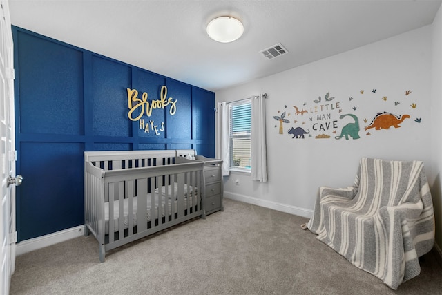 carpeted bedroom with a nursery area