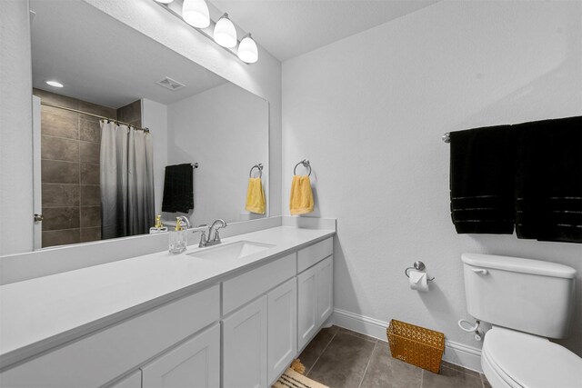 bathroom featuring toilet, vanity, tile patterned floors, and walk in shower