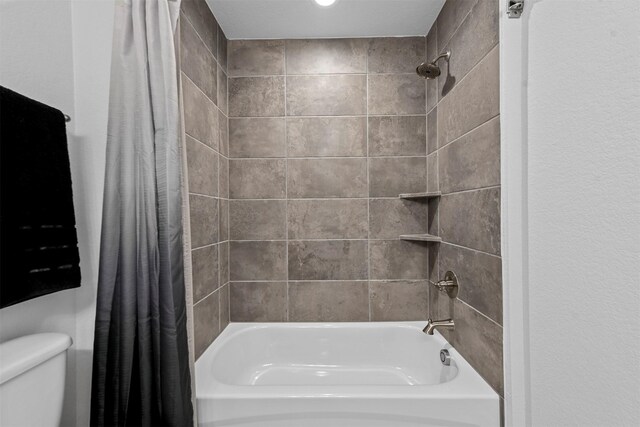 bathroom featuring shower / bath combo and toilet