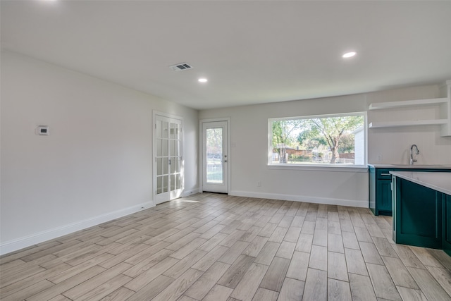 kitchen with light hardwood / wood-style floors, a wealth of natural light, and sink