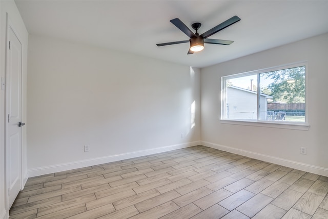 empty room with ceiling fan and light hardwood / wood-style flooring