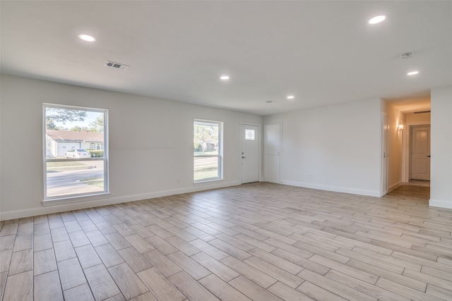 spare room featuring plenty of natural light and light hardwood / wood-style floors