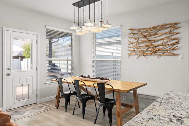 dining space featuring hardwood / wood-style flooring and an inviting chandelier