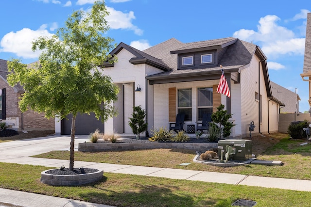 view of front of home with a porch, a garage, and a front yard