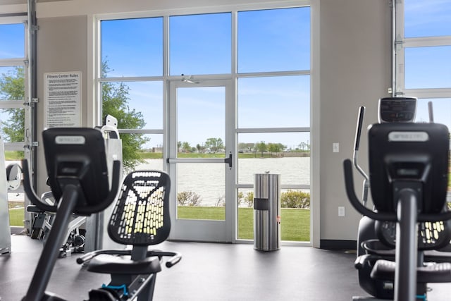 exercise room featuring a water view