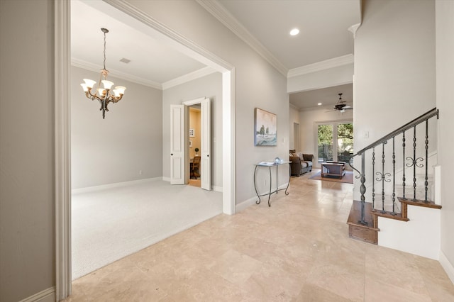 carpeted entrance foyer featuring crown molding and ceiling fan with notable chandelier