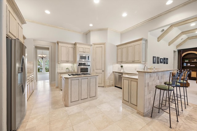 kitchen featuring lofted ceiling, kitchen peninsula, a chandelier, a breakfast bar, and appliances with stainless steel finishes