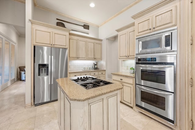 kitchen featuring light stone counters, decorative backsplash, a kitchen island, crown molding, and appliances with stainless steel finishes