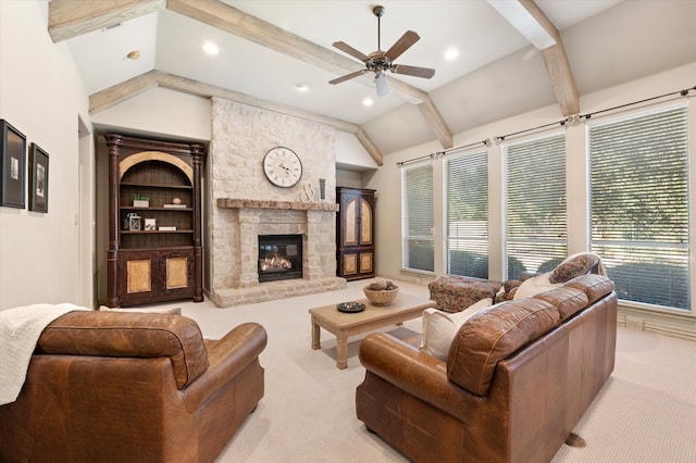 carpeted living room with lofted ceiling, built in features, ceiling fan, and a stone fireplace