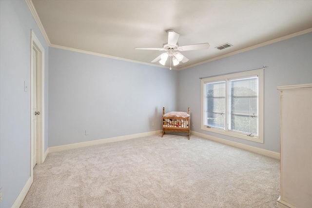 unfurnished room with ceiling fan, crown molding, and light carpet