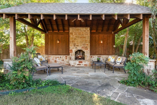 view of patio / terrace featuring a gazebo and an outdoor stone fireplace