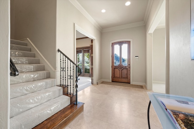 entryway with light tile patterned flooring and crown molding