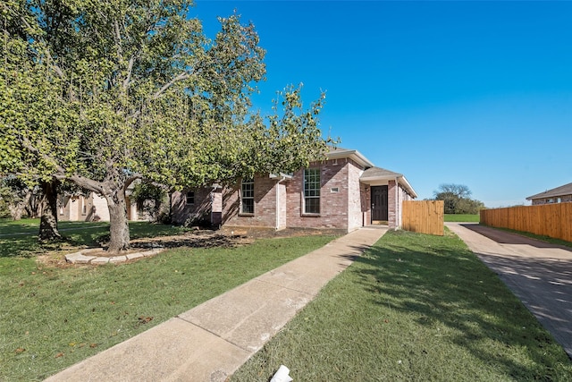 view of property hidden behind natural elements featuring a front yard