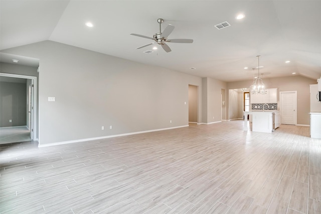 unfurnished living room with lofted ceiling, light hardwood / wood-style flooring, and ceiling fan with notable chandelier